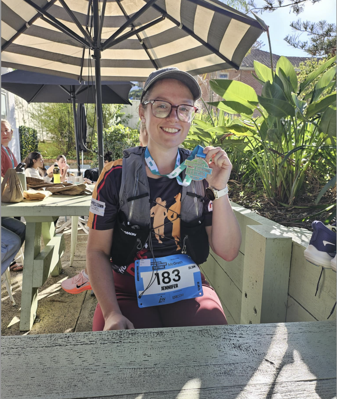 Jenny S. holding her half marathon medal
